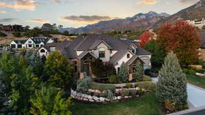 View of front facade with a garage, a mountain view, and a lawn