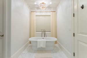 Bathroom with a notable chandelier and a bath