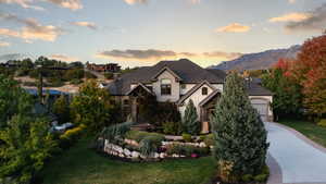 View of front facade featuring a mountain view, a yard, and a garage