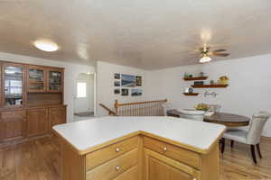 Kitchen featuring a kitchen island, light hardwood / wood-style flooring, and a textured ceiling