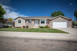 Ranch-style house featuring a front lawn and a garage