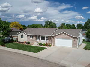 Ranch-style house featuring a garage and a front lawn