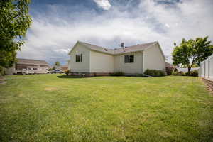 Back of house with a lawn