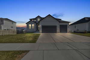 View of front of home with a garage, cooling unit, and a lawn