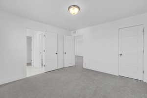 Unfurnished bedroom with light colored carpet