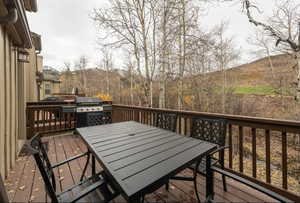 Wooden terrace featuring a grill