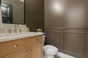 Bathroom featuring decorative backsplash, vanity, and toilet