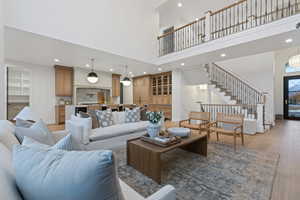 Living room with light hardwood / wood-style floors and a high ceiling