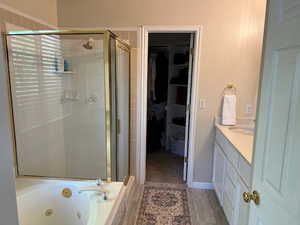 Bathroom with vanity, separate shower and tub, and hardwood / wood-style floors