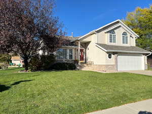 Tri-level home with a garage and a front lawn