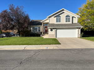 View of front facade with a front lawn and a garage