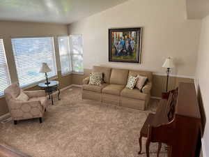 Living room featuring vaulted ceiling and carpet floors