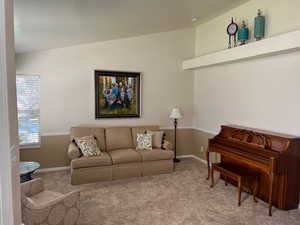 Carpeted living room with lofted ceiling