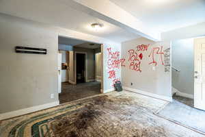 Empty room featuring a textured ceiling and beamed ceiling