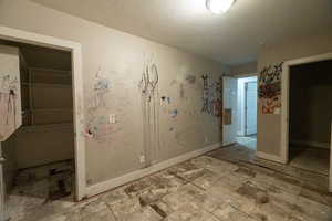 Unfurnished bedroom featuring a textured ceiling and a closet