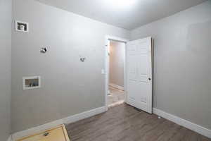 Laundry area featuring a textured ceiling, washer hookup, and hardwood / wood-style flooring