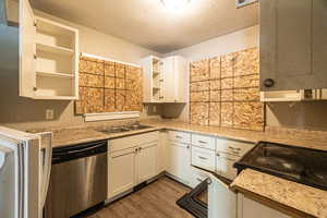 Kitchen featuring dishwasher, white cabinets, a textured ceiling, and dark hardwood / wood-style floors