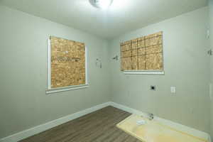 Interior space with a textured ceiling and dark wood-type flooring