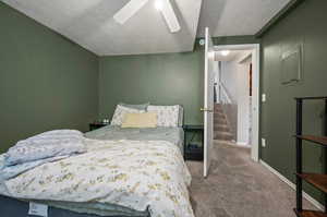 Bedroom with carpet, a textured ceiling, and ceiling fan