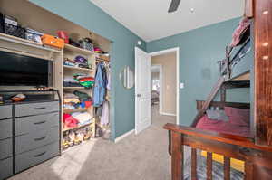 Bedroom with light colored carpet and ceiling fan