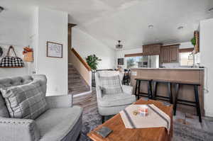 Living room featuring lofted ceiling, hardwood / wood-style floors, and a textured ceiling