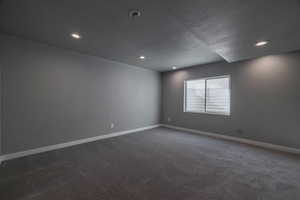 Carpeted empty room featuring a textured ceiling