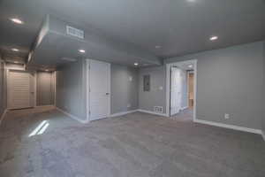 Unfurnished room featuring light carpet, a textured ceiling, and electric panel