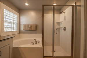 Bathroom featuring vanity and independent shower and bath