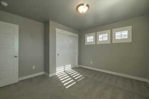 Unfurnished bedroom with carpet and a closet