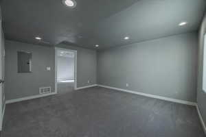 Empty room with carpet floors and electric panel