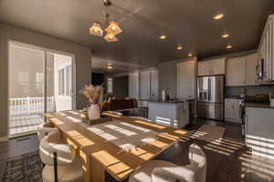 Dining room featuring sink, dark hardwood / wood-style floors, and a notable chandelier