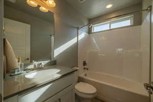 Full bathroom with tile patterned floors, vanity, toilet, and shower / washtub combination