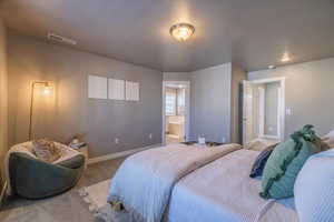 Bedroom with hardwood / wood-style floors and ensuite bathroom