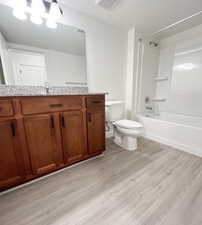 Full bathroom with toilet, shower / bathing tub combination, vanity, and wood-type flooring