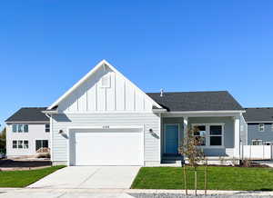 View of front of home with a front yard and a garage