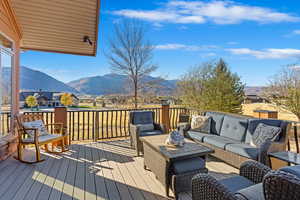 Wooden deck featuring an outdoor hangout area and a mountain view