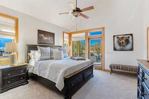 Primary Suite Bedroom with ceiling fan, light carpet, vaulted ceiling, and access to exterior back deck