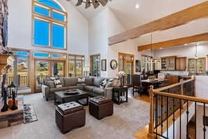 Living room with hardwood / wood-style flooring, high vaulted ceiling, beam ceiling, and a wealth of natural light