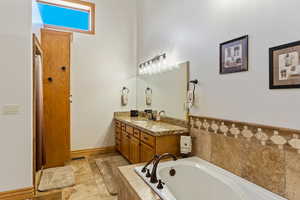 Primary Suite Bathroom with vanity and tiled bath