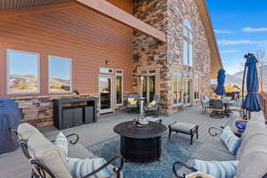 View of patio / terrace featuring a deck with mountain view and an outdoor living space with a fire pit