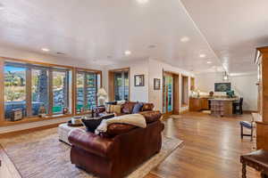 Living room with french doors, a textured ceiling, and light hardwood / wood-style floors