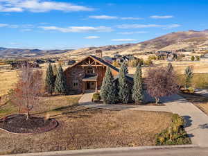 View of front of house with a mountain view and a front yard