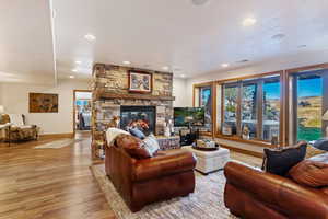 Living room featuring light hardwood / wood-style floors and a stone fireplace