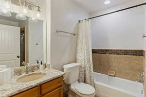 Full bathroom with vanity, toilet, tile walls, and shower / bath combo