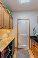 Laundry room currently set up as a coffee nook featuring light hardwood / wood-style floors and sink