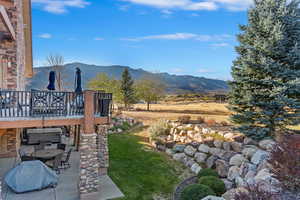 View of yard featuring a patio area and a deck with mountain view