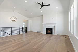 Grand living room with a fireplace, mantle, vaulted ceilings, and designer railing