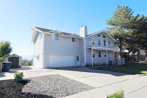 View of front of home with a storage unit, a balcony, and a garage