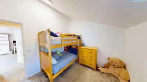 Carpeted bedroom with lofted ceiling