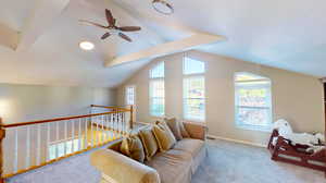 Interior space featuring vaulted ceiling with beams, light colored carpet, and ceiling fan